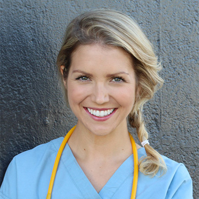 A nurse with scrubs on smiling.